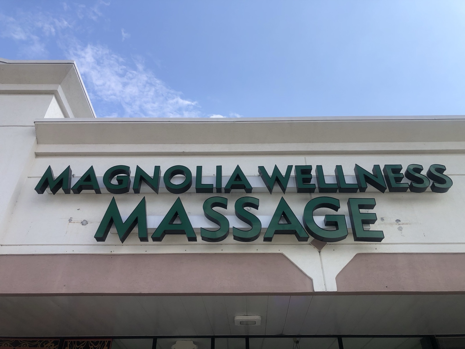 Exterior storefront signage of Magnolia Wellness Massage on FM 1488 in Magnolia, TX